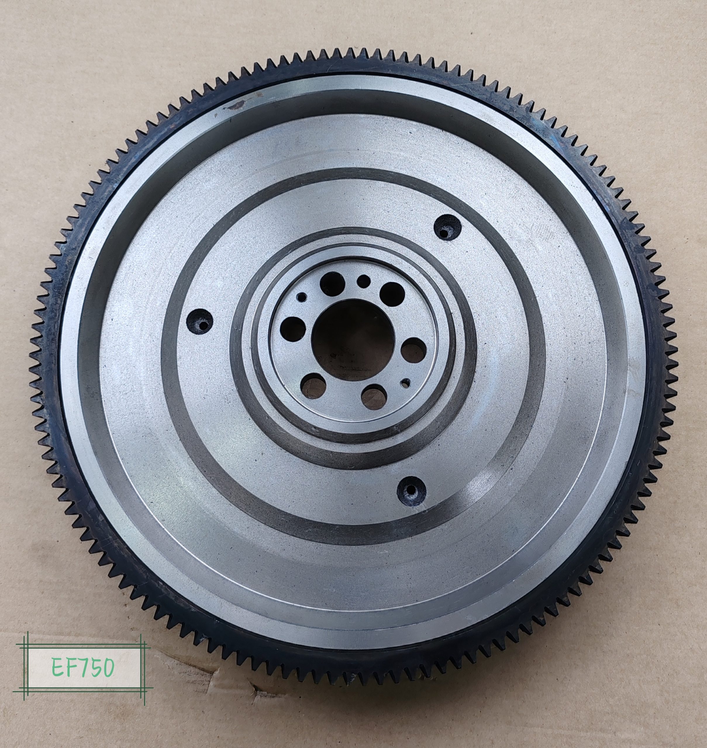 HINO EF750 flywheel front view with stamped identification showing 130T ring gear and dual friction surface