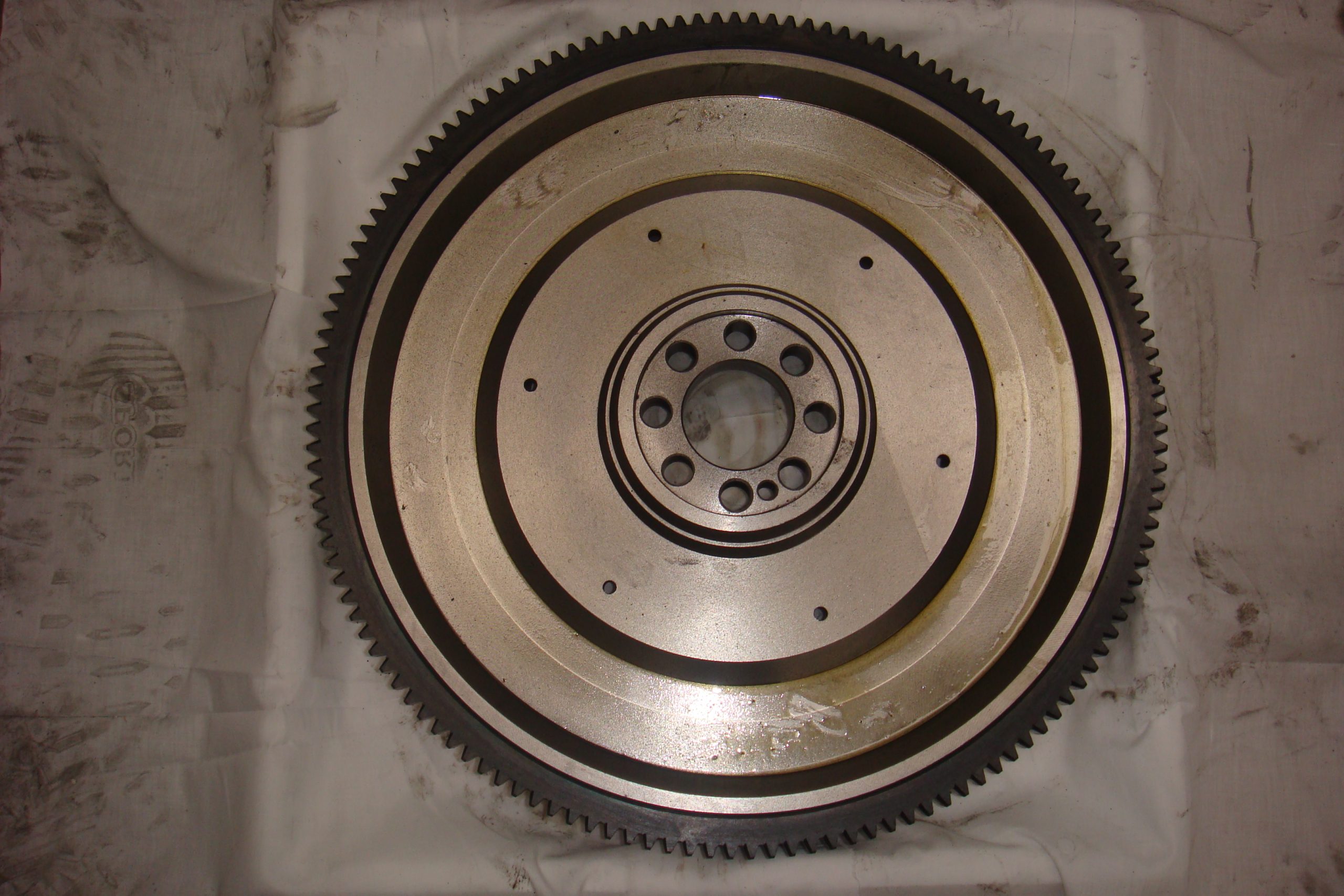 HINO EK100 flywheel front view showing 130T ring gear and crankshaft bolt pattern