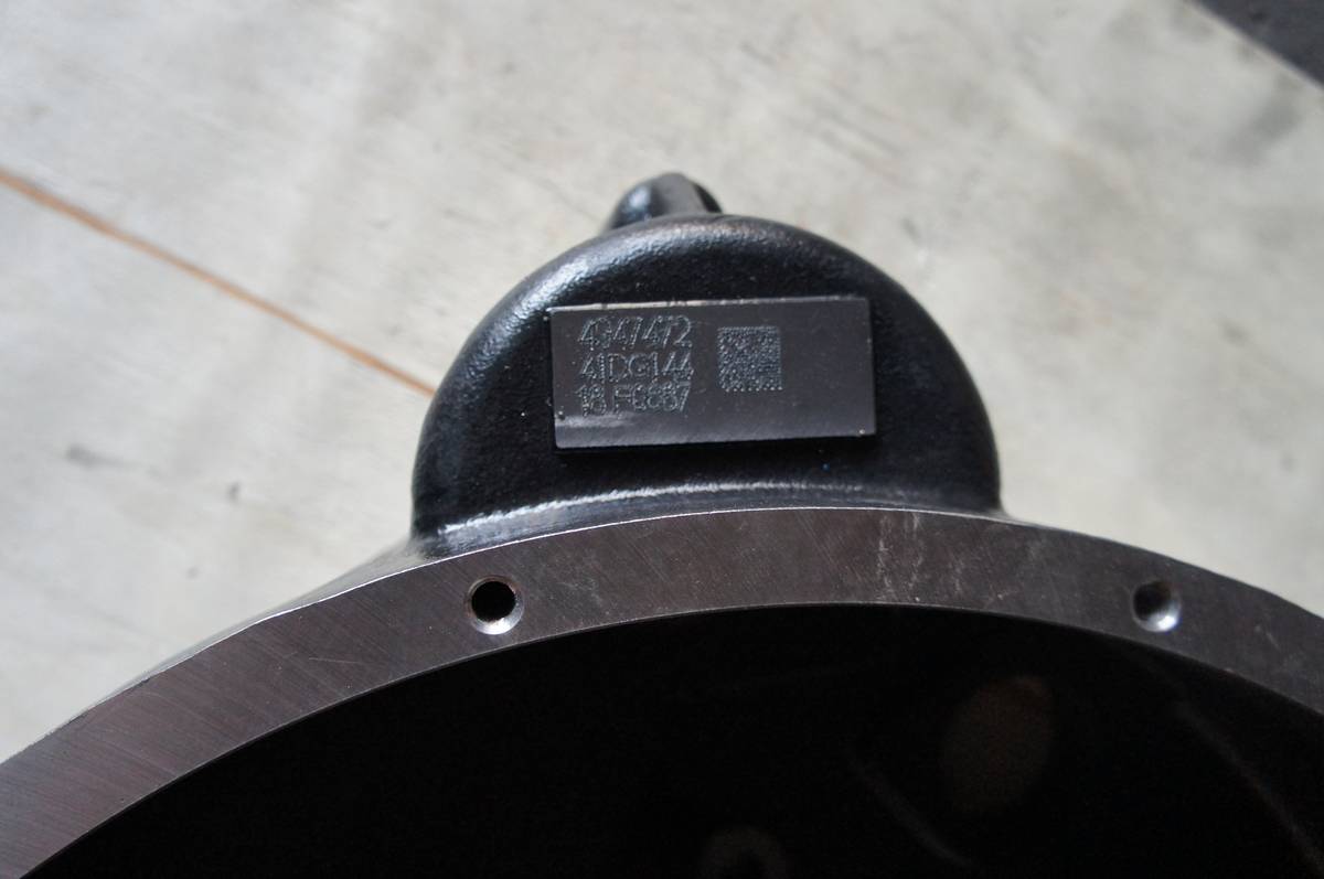Laser etched data plate on a flywheel housing showing the part number 4947472 and a data matrix code