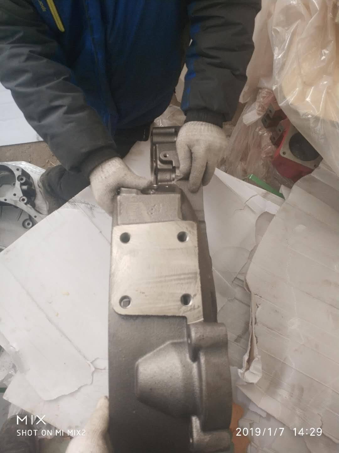 Large flywheel housing held by a worker, showing the size of the casting