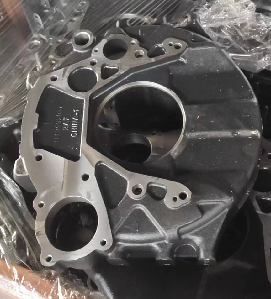 Flywheel housing with machined central pilot bore and cast identification panel