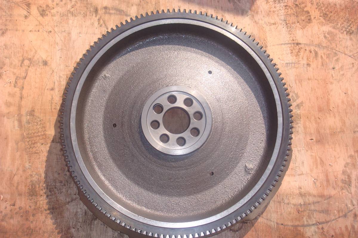 HINO J08C flywheel, front face showing dished friction surface, eight crank bolt holes and the ring gear on the outer diameter