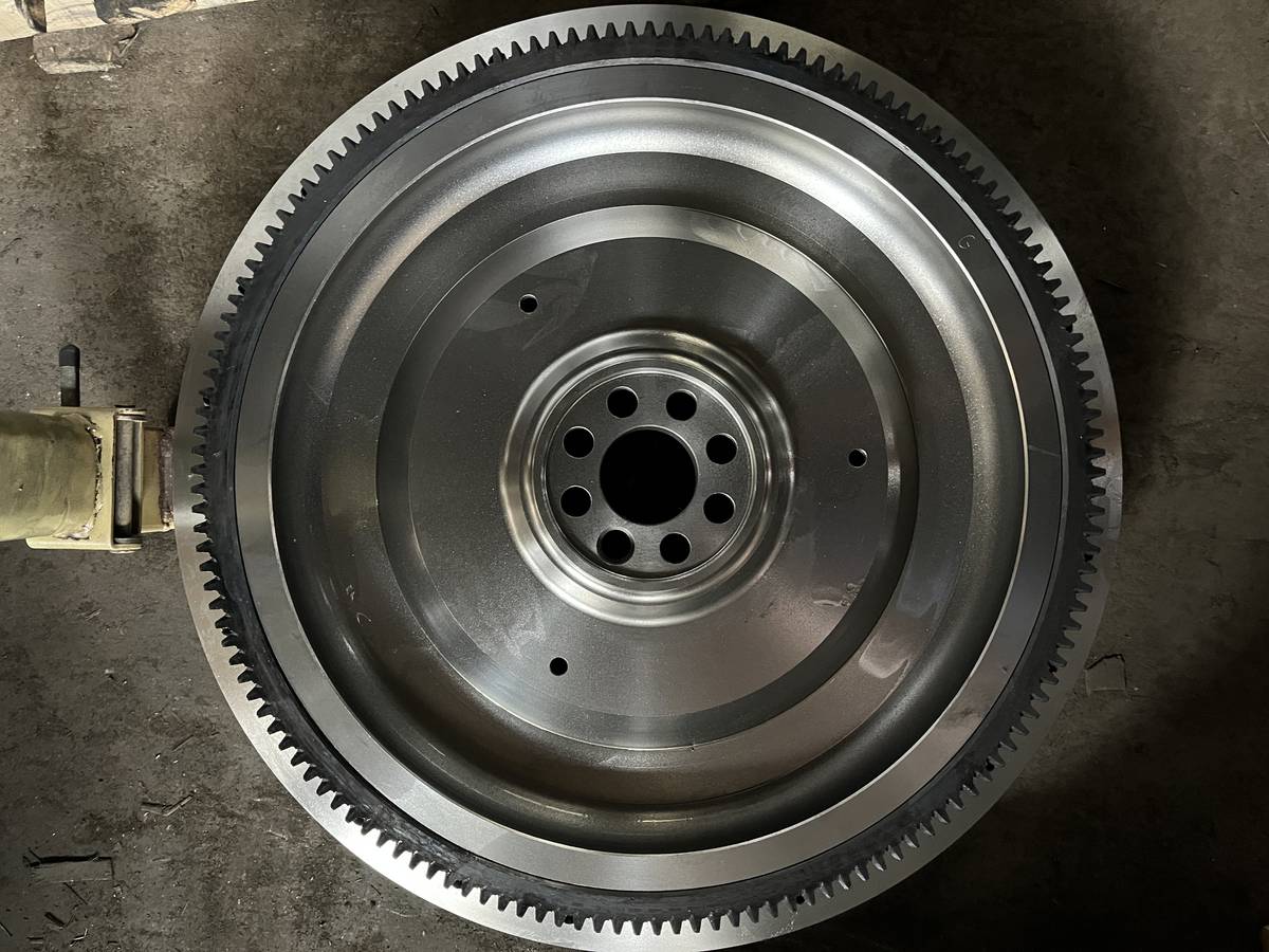 HINO J08E flywheel in the flat form, wider flatter friction band and coarser ring gear tooth pitch