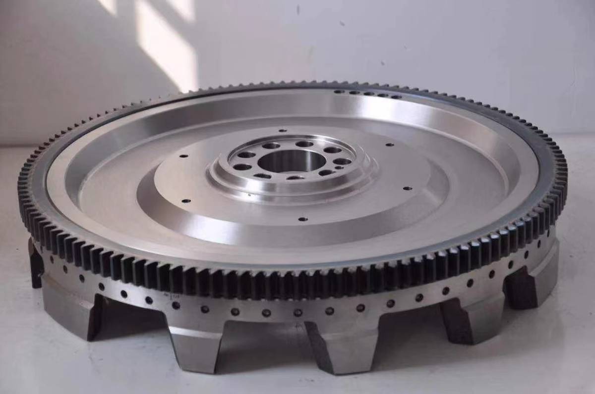 HINO P11C flywheel with counterweight lobes visible on the underside, ring gear and drilled crank flange