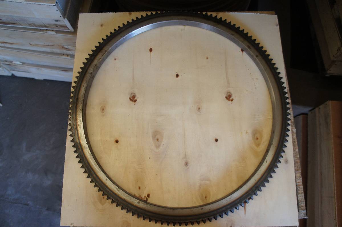 Ring gear standing upright on a plywood crate face, showing the full tooth ring and body width