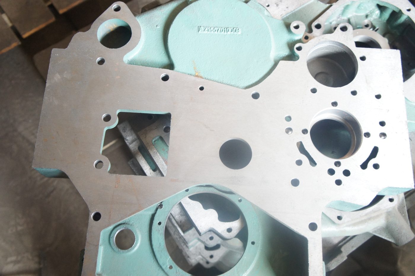 Front face of a Sinotruk HOWO timing gear housing — machined mounting face, dowel pin holes and seal groove